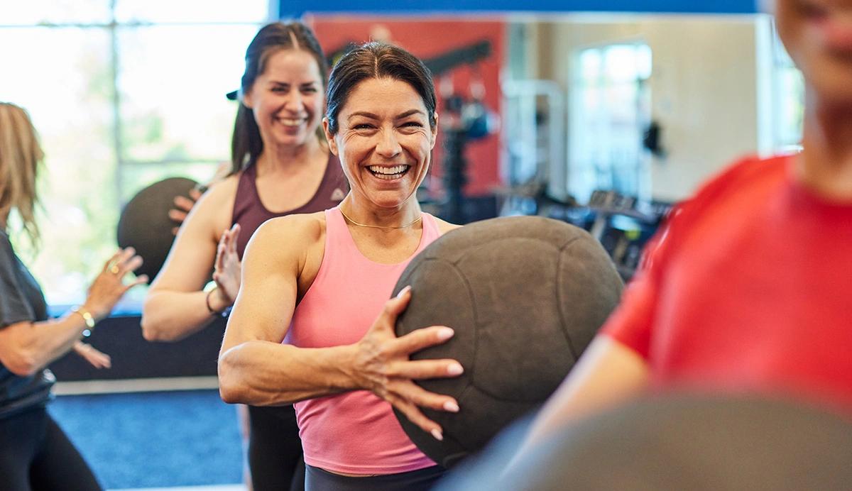 woman in a group class holding a medicine ball