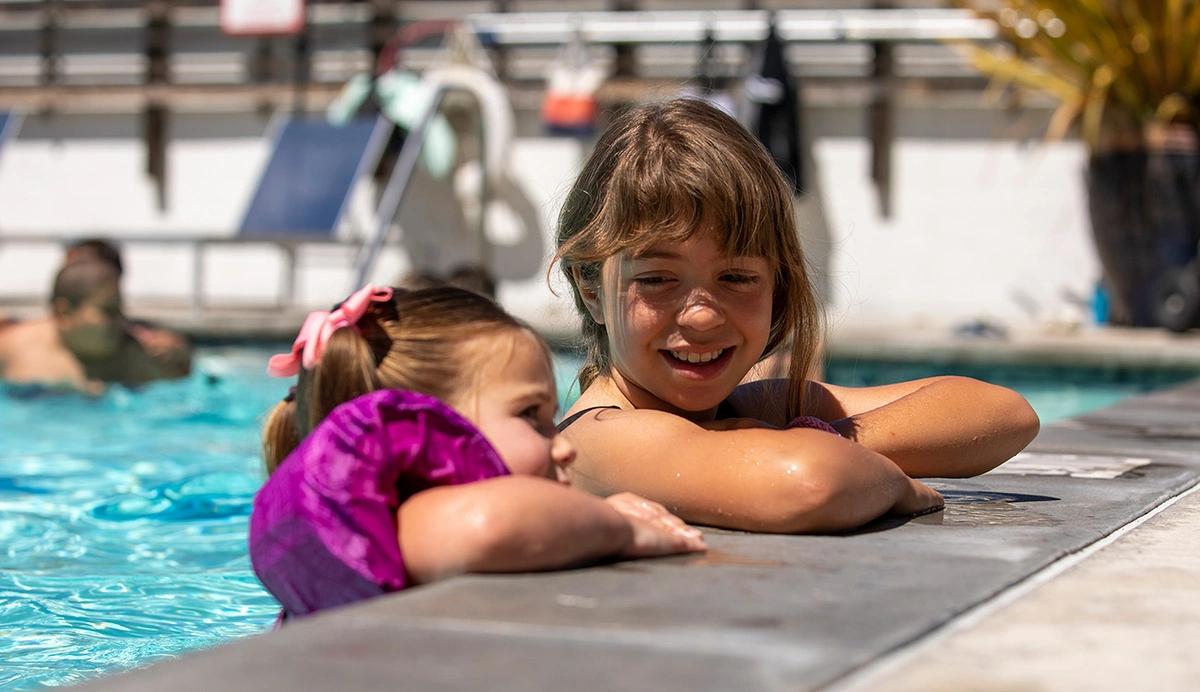 Two children on the edge of a swimming pool