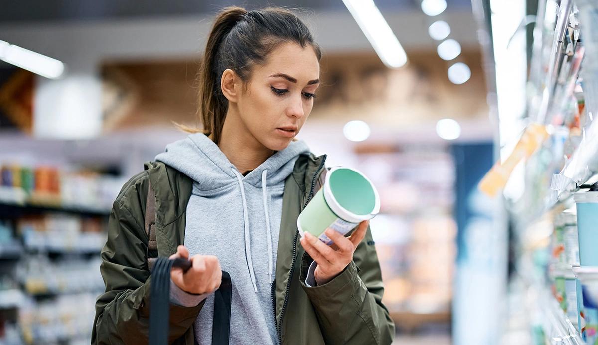 Woman Reading a food label in a grocery store